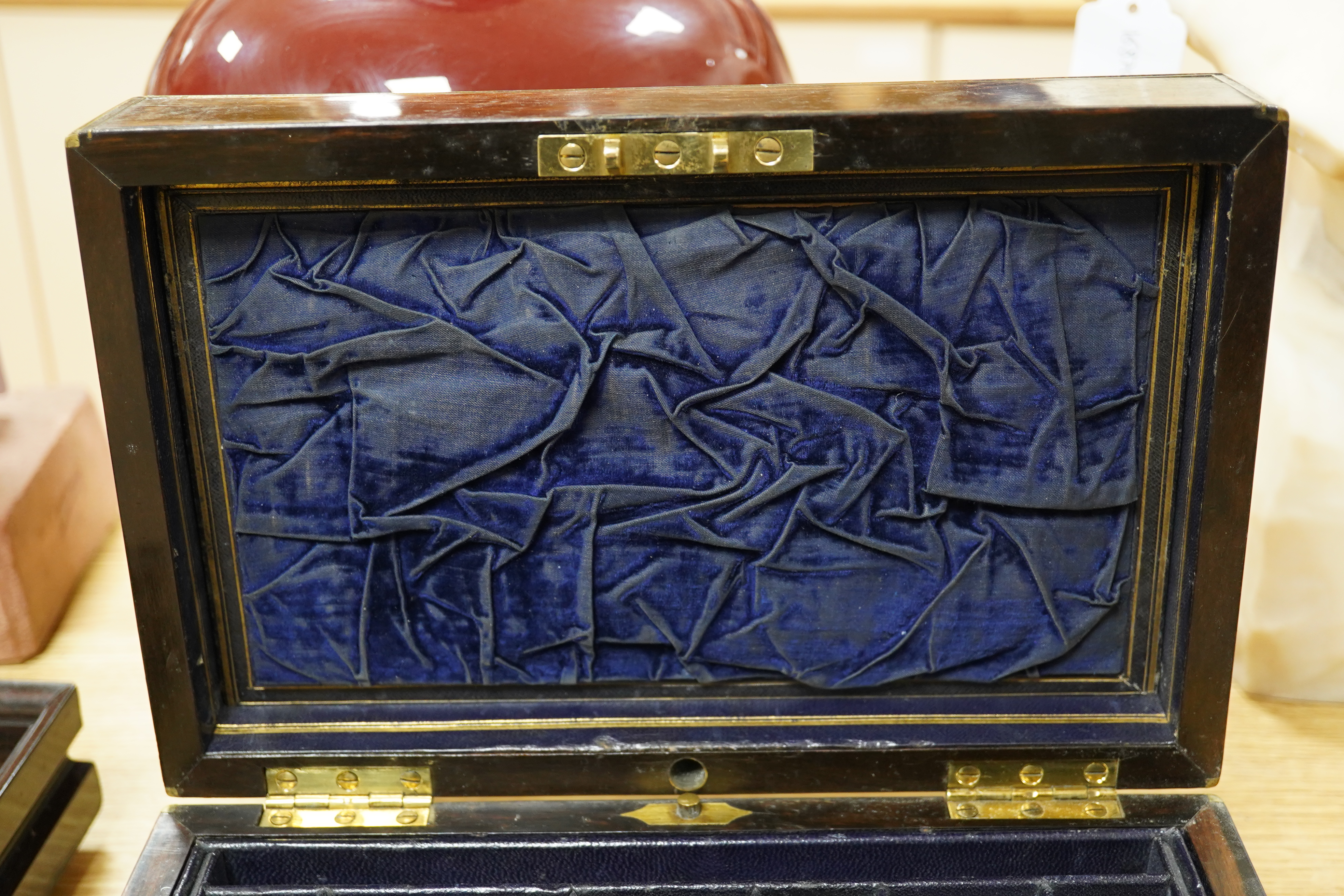 A Victorian brass bound coromandel wood jewellery casket, with velvet lined lid, a fitted leather and velvet top compartment shelf and base lower drawer. 13cm high x 28cm wide. Condition - some splits to the veneer on th